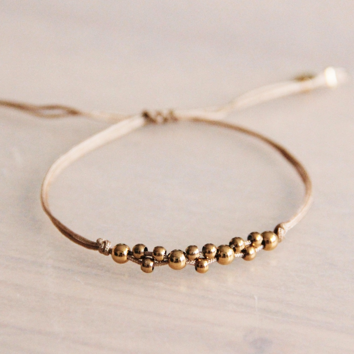 Satijnen armband met goudkleurige kralen - Taupe/goud