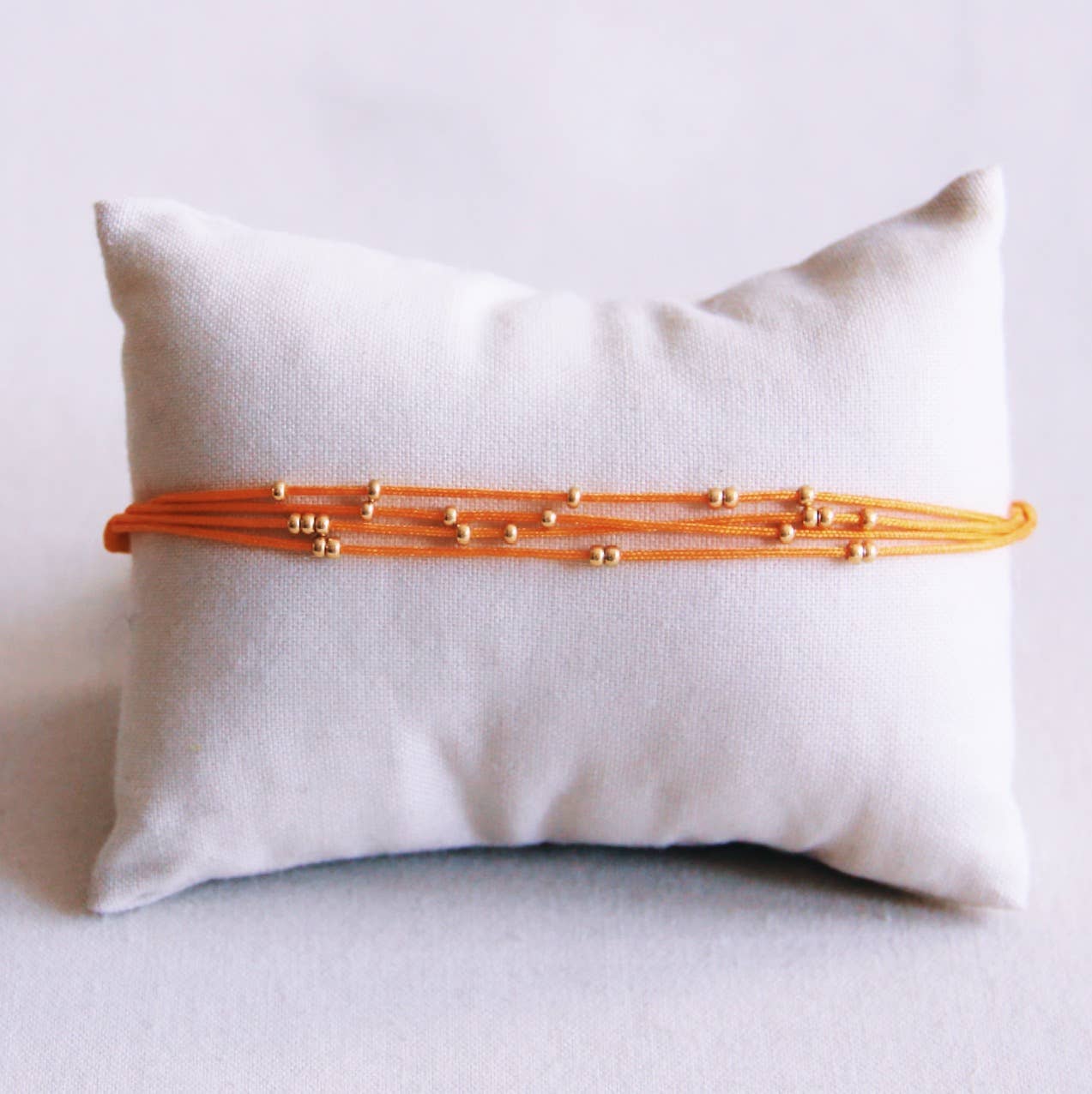 Viervoudige satijnen armband met kralen - oranje