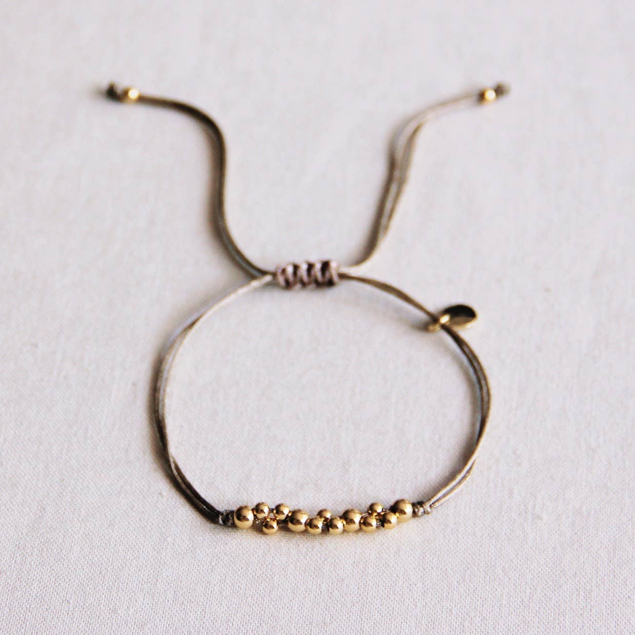 Satijnen armband met goudkleurige kralen - Taupe/goud